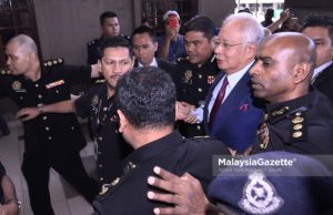 Bekas Perdana Menteri, Datuk Seri Najib Tun Razak sambil diiringi pegawai SPRM dan anggota polis ketika hadir untuk pertuduhan di Mahkamah Sesyen, Kompleks Mahkamah Kuala Lumpur. foto NOOR ASREKUZAIREY SALIM, 04 JULAI 2018