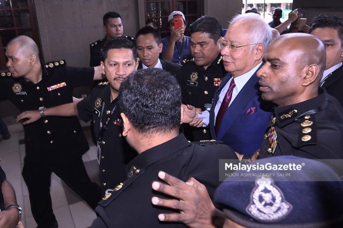 Bekas Perdana Menteri, Datuk Seri Najib Tun Razak sambil diiringi pegawai SPRM dan anggota polis ketika hadir untuk pertuduhan di Mahkamah Sesyen, Kompleks Mahkamah Kuala Lumpur. foto NOOR ASREKUZAIREY SALIM, 04 JULAI 2018