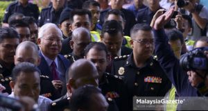 Bekas Perdana Menteri, Datuk Seri Najib Tun Razak sambil diiringi pegawai SPRM dan anggota polis ketika hadir untuk pertuduhan di Mahkamah Sesyen, Kompleks Mahkamah Kuala Lumpur. foto NOOR ASREKUZAIREY SALIM, 04 JULAI 2018