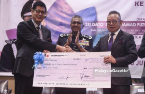 Pengerusi Koperasi PDRM, Tan Sri Hussin Ismail menerima replika cek dividen keuntungan daripada Pengerusi Kop Mantap, Datuk Iskandar Datuk Abdul Malik sambil diperhatikan oleh Ketua Polis Negara, Tan Sri Mohamad Fuzi Harun pada Mesyuarat Agung Tahunan Perwakilan Koperasi Polis Diraja Malaysia di Dewan Bankuet, Hotel Kuala Lumpur International, Jalan Raya Muda, Kuala Lumpur. foto AFFAN FAUZI, 10 JULAI 2018