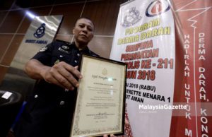 Sarjan Mejar Mohd Zaini Ahmad bergambar bersama sijil penderma paling aktif pada Majlis Perasmian Program Derma Darah Sempena Peringatan Hari Polis ke-211 Tahun 2018 di Ibu Pejabat Polis Bukit Aman, Kuala Lumpur. foto IQBAL BASRI, 11 JULAI 2018
