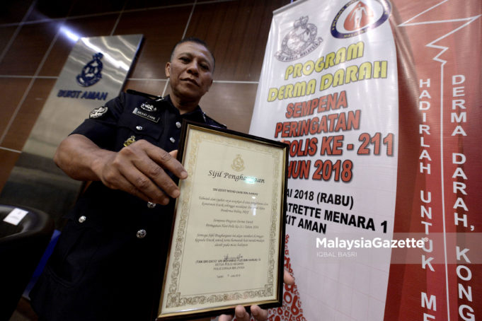 Sarjan Mejar Mohd Zaini Ahmad bergambar bersama sijil penderma paling aktif pada Majlis Perasmian Program Derma Darah Sempena Peringatan Hari Polis ke-211 Tahun 2018 di Ibu Pejabat Polis Bukit Aman, Kuala Lumpur. foto IQBAL BASRI, 11 JULAI 2018