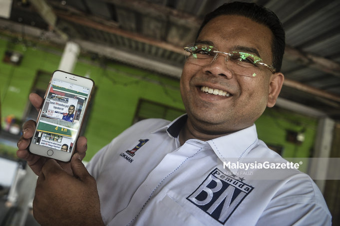 Calon Barisan Nasional untuk Pilihan Raya Kecil Sungai Kandis, Datuk Lokman Noor Adam menunjukkan poster kempen beliau yang diarahkan turun oleh pihak Suruhanjaya Pilihan Raya (SPR) pada Program Ziarah Kasih sempena kempen Pilihan Raya Kecil N. 49 Sungai Kandis di Lorong Abdullah, Batu 7, Jalan Kebun, Shah Alam, Selangor. foto AFFAN FAUZI, 30 JULAI 2018