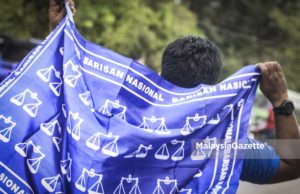 Penyokong BN membawa bendera lambang dacing pada program kempen di DUN Sungai Kandis, semalam.