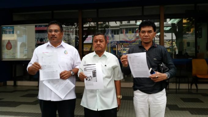 Syed Hassan (kiri) dan Ruslan (dua dari kiri) menunjukkan laporan polis yang dibuatnya berhubung dakwaan menghasut ke atas peguam dan aktivis Pakatan Harapan di depan Balai Polis Dang Wangi, Kuala Lumpur.