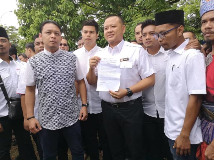 Rizam (tengah) menunjukkan laporan polis yang dibuatnya ke atas Kula Segaran di IPD Shah Alam hari ini.