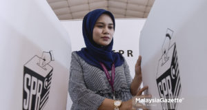 Petugas SPR, Arba’inah Mohamd Sapari menyusun penghadang tempat mengundi sempena Pilihan Raya Kecil (PRK) N.49 Sungai Kandis ketika tinjauan lensa Malaysia Gazette di Dewan Klang Jaya, Klang, Selangor. foto SYAFIQ AMBAK, 03 OGOS 2018