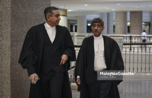 Peguam, Mohd Haniff Khatri Abdulla (kanan) yang mewakili Perdana Menteri, Tun Dr. Mahathir Mohamad mendengar penerangan daripada Datuk Mohd Hafarizam Harun (kiri), peguam yang mewakili Bekas Perdana Menteri, Datuk Seri Najib Tun Razak ketika hadir pada sesi pendengaran permohonan kebenaran bagi rayuan ke Mahkamah Persekutuan berhubung kes saman salah guna jawatan awam terhadap Najib berkaitan 1MDB di Istana Kehakiman, Putrajaya. foto HAZROL ZAINAL, 06 OGOS 2018.
