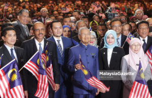 Perdana Menteri, Tun Dr. Mahathir Mohamad (tiga kanan) diiringi Timbalan Perdana Menteri, Datuk Seri Wan Azizah Wan Ismail (kanan) mengibarkan bendera bersama pegawai dan diplomatik sambil mengibarkan jalur gemilang pada Program Town Hall bersama Persatuan Perkhidmatan Tadbir dan Diplomatik dengan kerjasama Institut Tadbiran Awam Negara (INTAN) di Dewan Perdana, Pusat Konvensyen Antarabangsa Putrajaya (PICC), Putrajaya. foto MIRZA HASIM, 15 OGOS 2018