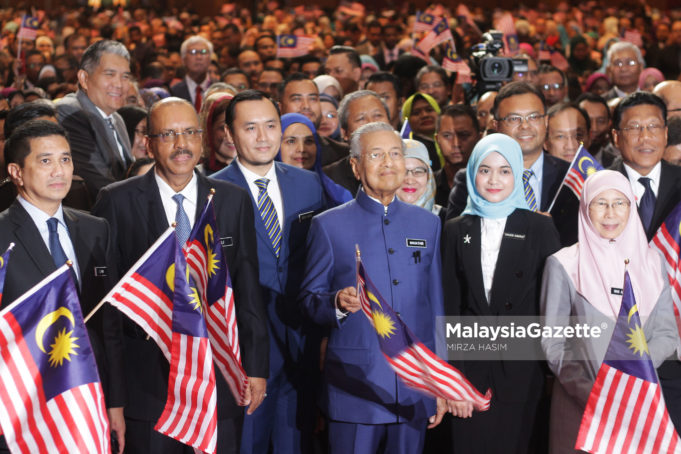 Perdana Menteri, Tun Dr. Mahathir Mohamad (tiga kanan) diiringi Timbalan Perdana Menteri, Datuk Seri Wan Azizah Wan Ismail (kanan) mengibarkan bendera bersama pegawai dan diplomatik sambil mengibarkan jalur gemilang pada Program Town Hall bersama Persatuan Perkhidmatan Tadbir dan Diplomatik dengan kerjasama Institut Tadbiran Awam Negara (INTAN) di Dewan Perdana, Pusat Konvensyen Antarabangsa Putrajaya (PICC), Putrajaya. foto MIRZA HASIM, 15 OGOS 2018