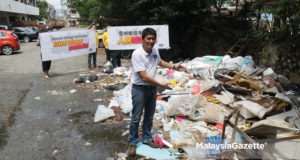 Calon MCA N.27 Balakong, Tan Chee Teong menunjukkan sampah-sarap antara punca masalah tertinggi kes denggi yang dihadapi oleh penduduk di Taman Seri Cheras, Selangor. foto MIRZA HASIM, 23 OGOS 2018