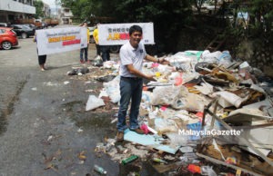 Calon MCA N.27 Balakong, Tan Chee Teong menunjukkan sampah-sarap antara punca masalah tertinggi kes denggi yang dihadapi oleh penduduk di Taman Seri Cheras, Selangor. foto MIRZA HASIM, 23 OGOS 2018