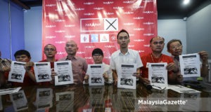 Calon Pakatan Harapan N.27 Balakong, Wong Siew Ki (tengah) sambil diiringi ADUN Seri Kembangan, Ean Yong Hian Wah (tiga kanan) menunjukkan laporan mengenai tindakan undang undang terhadap fitnah yang dilakukan oleh calon MCA di Bilik Gerakan Utama Pakatan Harapan, Cheras Perdana, Selangor. foto AFFAN FAUZI, 27 OGOS 2018.