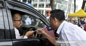 Calon Pakatan Harapan (PH), Halimey Abu Bakar (kanan) mengedarkan Jalur Gemilang kepada orang ramai pada Bulan Kemerdekaan sempena kempen Pilihan Raya Kecil (PRK) N.32 Seri Setia di Pusat Penjaja SS5d/2 Kelana Jaya, Petaling Jaya. Selangor. foto FAREEZ FADZIL, 27 OGOS 2018