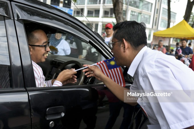 MGF27082018_WALKABOUT CALON PH_11 Calon Pakatan Harapan (PH), Halimey Abu Bakar (kanan) mengedarkan Jalur Gemilang kepada orang ramai pada Bulan Kemerdekaan sempena kempen Pilihan Raya Kecil (PRK) N.32 Seri Setia di Pusat Penjaja SS5d/2 Kelana Jaya, Petaling Jaya. Selangor. foto FAREEZ FADZIL, 27 OGOS 2018
