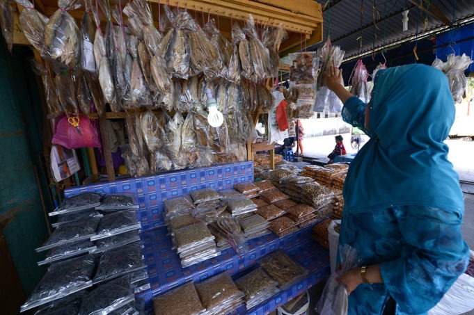 Seorang pelanggan sedang memilih pelbagai jenis ikan masin yang dijual di Pusat Jualan Ikan Masin, Kota Kinabalu, Sabah. Foto/SAFWAN MANSOR. 24 DISEMBER 2013