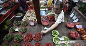 Seorang peniaga menyusun cili dan sayur-sayuran untuk dijual kepada pelanggan semasa tinjauan lensa MalaysiaGazette di Pasar Chow Kit, Kuala Lumpur. foto SYAFIQ AMBAK, 14 JUN 2018