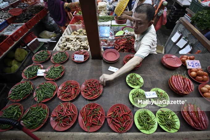 Seorang peniaga menyusun cili dan sayur-sayuran untuk dijual kepada pelanggan semasa tinjauan lensa MalaysiaGazette di Pasar Chow Kit, Kuala Lumpur. foto SYAFIQ AMBAK, 14 JUN 2018