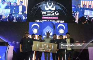 Menteri Belia dan Sukan Malaysia, Syed Saddiq Syed Abdul Rahman bergambar bersama juara kesuluruhan pasukan "Froz Fire" sambil memegang replika cek wang tunai pada Majlis Penutup Malaysian National Qualifiers Finals di Quill City Mall, Kuala Lumpur. foto AFFAN FAUZI, 23 SEPTEMBER 2018