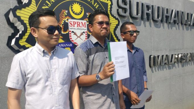 Ahmad Syukri (tengah) menunjukkan laporan SPRM yang dibuatnya ke atas seorang Setiausaha Politik sebuah kementerian kerana didakwa melakukan rasuah.