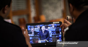 Dua anggota polis bantuan, Abdul Hamid Karim (kanan) Mohamad Izzat Jaafar (kiri) dilihat tekun menonton pengumuman bajet 2019 oleh Menteri Kewangan, Lim Guan Eng ketika tinjauan lensa Malaysia Gazette di sekitar Putrajaya. foto HAZROL ZAINAL, 02 NOVEMBER 2018.