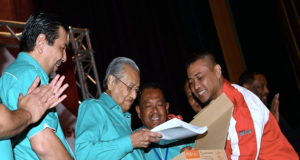 Perdana Menteri Tun Dr Mahathir Mohamad (dua, kiri) menerima Buku Laporan Tiga Tahunan 2015-2018 daripada kakitangan Pos Malaysia, Mohammad Sarwani Ab Ghani sebagai gimik perasmian Persidangan Perwakilan Kesatuan Pekerja-Pekerja Pakaian Seragam Pos Malaysia Berhad . Turut hadir Pengerusi Pos Malaysia, Datuk Mohammad Zainal Shaari (kiri) dan Pemangku Presiden UPUS, Ahmad Tarmizi Taib (tiga, kiri).
