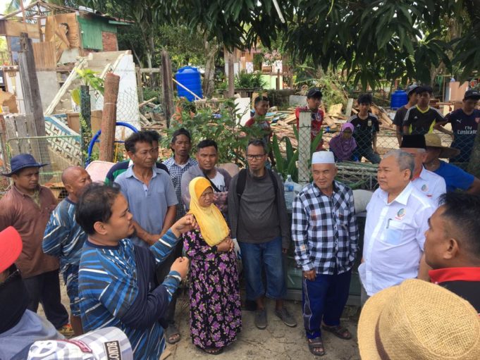 Dr. Ibrahim (kanan) mendengar keluahan penduduk yang mana rumah mereka di di Kampung Tinosa 2, Sandakan kena roboh.