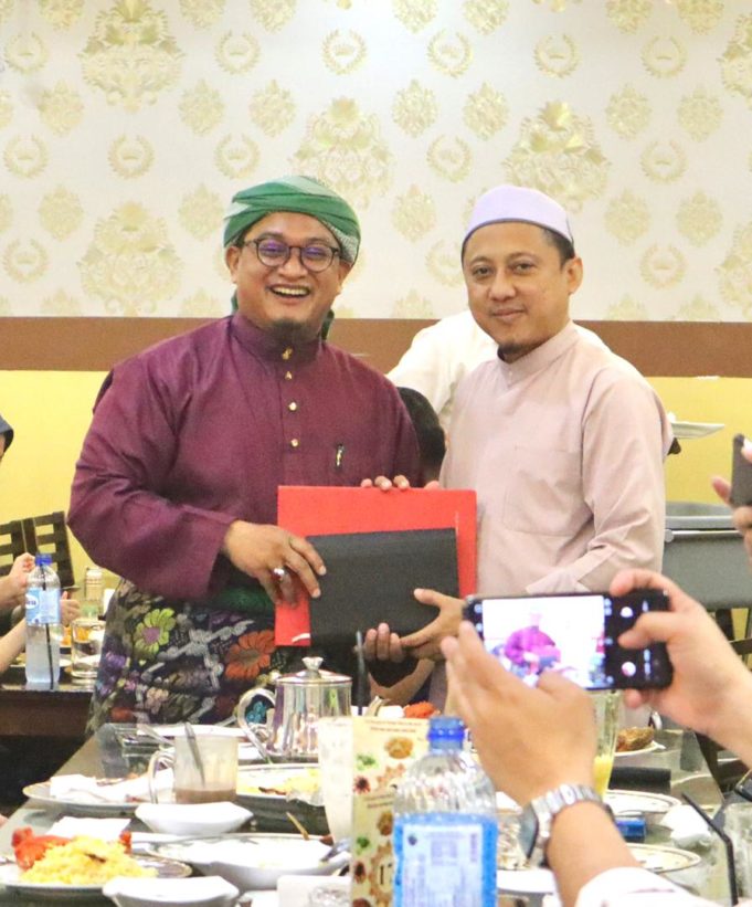 Nasrudin (kiri) menyerahkan fail gerak kerja kepada Kamaruzaman yang dilantik Ketua Penerangan Pas Malaysia yang baharu.