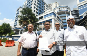 Mohd Sumali (dua dari kiri) menunjukkan laporan polis yang dibuatnya di Balai Polis Dang Wangi tengah hari ini.