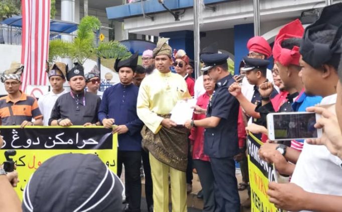 wiramemo Nasrul Ali Hasan (tengah) menyerahkan memorandum menggesa polis mengharamkan Dong Zong kepada Abdul Rahim dari Bahagian Komunikasi Korporat Bukit Aman.