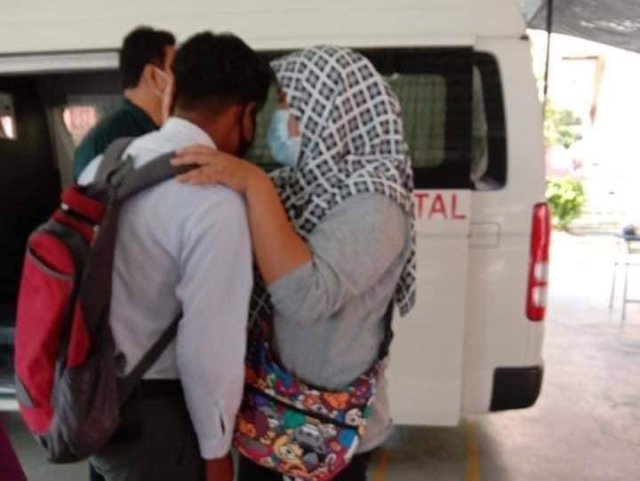 Muhammad Haikal Iskandar is being comforted by his teacher after he met his father for the last time at SMK Simpang Beluru, Kuala Kangsar today. PIX: Facebook