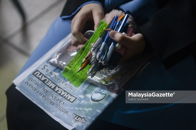    The Sijil Pelajaran Malaysia 2020 (SPM 2020) students holding on to their stationery prior to sitting for their Bahasa Melayu Paper 1 examination at Sekolah Menengah Setiabudi, Gombak, Kuala Lumpur.  PIX: HAFIZ SOHAIMI / MalaysiaGazette / 22 FEBRUARY 2021.