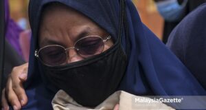 Norlida Abu Hassan, 50, the adopted mother of Zubaidi Amir Qusyairi Abd Malek, 7, looking heart wrenched after Amir is laid to rest at the Padang Lebar Islamic Cemetery in Simpang Bekoh, Melaka. PIX: SYAFIQ AMBAK / MalaysiaGazette / 01 FEBRUARY 2021
