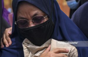 Norlida Abu Hassan, 50, the adopted mother of Zubaidi Amir Qusyairi Abd Malek, 7, looking heart wrenched after Amir is laid to rest at the Padang Lebar Islamic Cemetery in Simpang Bekoh, Melaka. PIX: SYAFIQ AMBAK / MalaysiaGazette / 01 FEBRUARY 2021