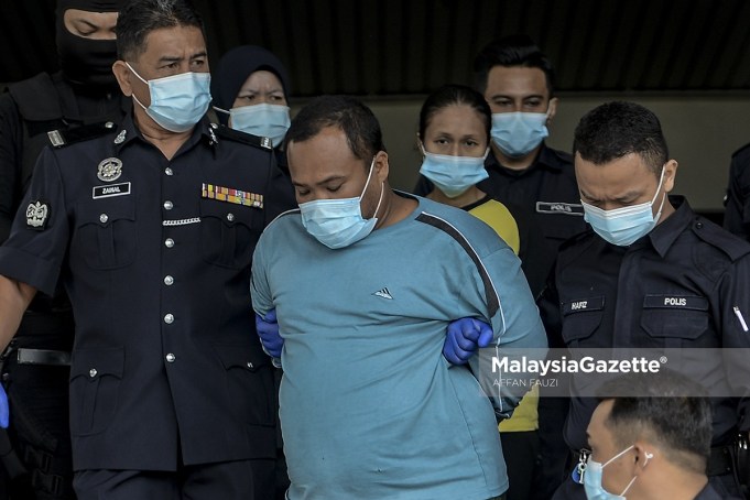 The two suspects, Mohd. Fadzli Abdull Razak (stepfather) and Zuraida Atan (mother) are escorted by the police from the Melaka Criminal Investigation Department (CID) to the Ayer Keroh Courts Complex to face charges for murdering and abusing Zubaidi Amir Qusyairi Abd. Malek. PIX: AFFAN FAUZI / MalaysiaGazette / 10 FEBRUARY 2021