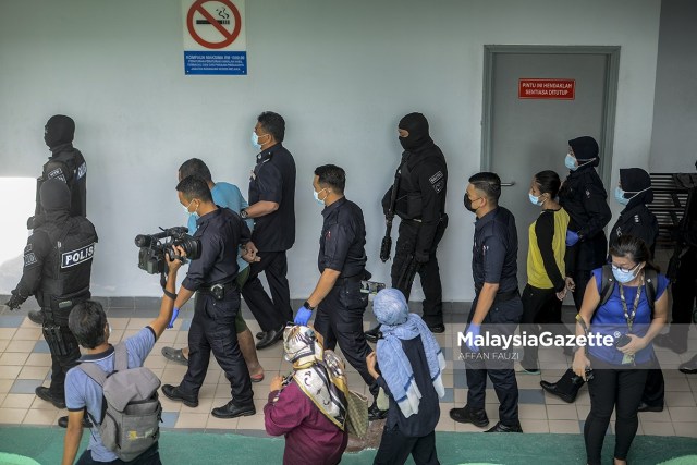 The two accused, Mohd. Fadzli Abdull Razak and Zuraida Atan are escorted by the police from the Melaka Criminal Investigation Department (CID) to the court to face murder and abuse charges of Zubaidi Amir Qusyairi Abd. Malek at the Melaka Courts Complex in Ayer Keroh.     PIX: AFFAN FAUZI / MalaysiaGazette / 10 FEBRUARY 2021
