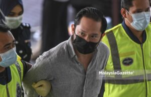 The founder of Sugarbook mobile application, Chan Eu Boon is escorted by the police to be charged at the Shah Alam Courts Courts Complex. PIX: SYAFIQ AMBAK / MalaysiaGazette / 24 FEBRUARY 2021