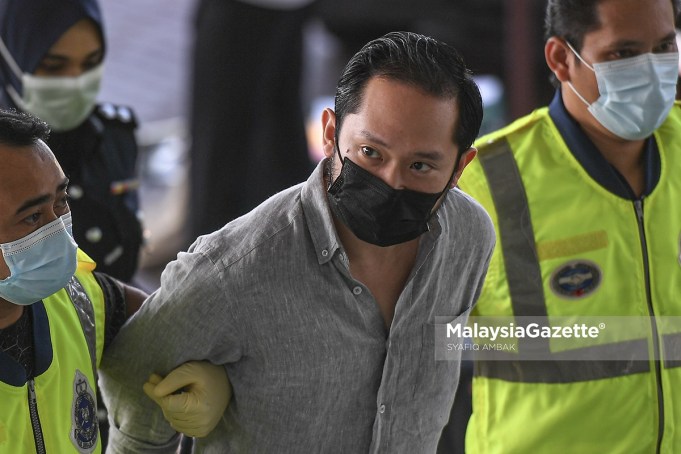 The founder of Sugarbook mobile application, Chan Eu Boon is escorted by the police to be charged at the Shah Alam Courts Courts Complex. PIX: SYAFIQ AMBAK / MalaysiaGazette / 24 FEBRUARY 2021
