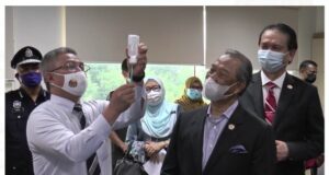 Health Minister Dr Adham Baba showing the LDV syringe of the Pfizer-BioNTech Covid-19 vaccine to Prime Minister Tan Sri Muhyiddin Yassin as Malaysia kicks of its National Covid-19 Immunisation Programme PIX: Ministry of Health