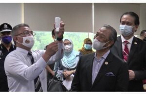 Health Minister Dr Adham Baba showing the LDV syringe of the Pfizer-BioNTech Covid-19 vaccine to Prime Minister Tan Sri Muhyiddin Yassin as Malaysia kicks of its National Covid-19 Immunisation Programme PIX: Ministry of Health