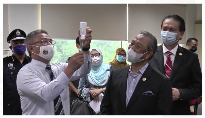 Health Minister Dr Adham Baba showing the LDV syringe of the Pfizer-BioNTech Covid-19 vaccine to Prime Minister Tan Sri Muhyiddin Yassin as Malaysia kicks of its National Covid-19 Immunisation Programme PIX: Ministry of Health