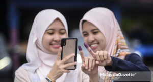 right to vote (Picture for representational purposes only) Twin sisters Asriyani As’ari, and Asriyana As’ari taking a wefie after casting their votes at the P. 165 Tanjung Piai by-election. PIX: SYAFIQ AMBAK / MalaysiaGazette / 16 NOVEMBER 2019 Undi 18 voters vote