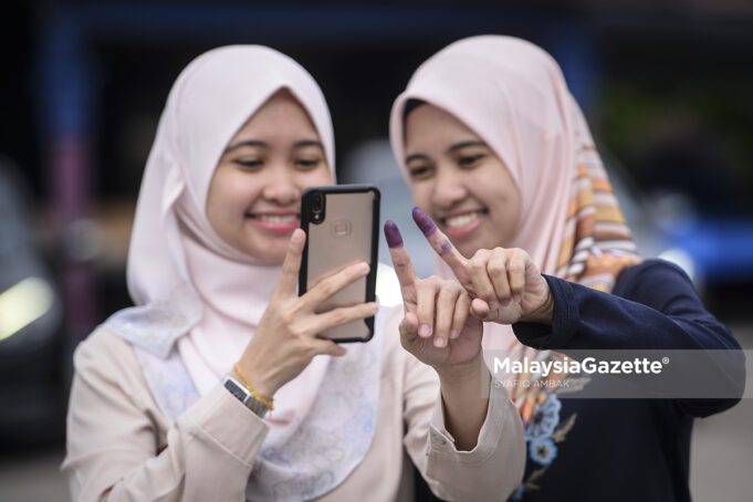 right to vote (Picture for representational purposes only) Twin sisters Asriyani As’ari, and Asriyana As’ari taking a wefie after casting their votes at the P. 165 Tanjung Piai by-election. PIX: SYAFIQ AMBAK / MalaysiaGazette / 16 NOVEMBER 2019 Undi 18 voters vote