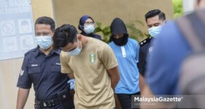 The police escort a couple of lovers to the Bandar Baru Bangi Court for ramming into a civil servant during an inspection at McDonald’s Bandar Baru Bangi on Tuesday. PIX: HAFIZ SOHAIMI / MalaysiaGazette /12 MARCH 2021