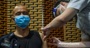 Reaksi anggota polis yang menerima suntikan vaksin COVID-19 khas kepada petugas barisan hadapan di Sunway Pyramid Convention Centre, Petaling Jaya. Foto MOHD ADZLAN, 11 MAC 2021.Reaksi anggota polis yang menerima suntikan vaksin COVID-19 khas kepada petugas barisan hadapan di Sunway Pyramid Convention Centre, Petaling Jaya. Foto MOHD ADZLAN, 11 MAC 2021. civil servants Covid-19 vaccine JPA vaccination