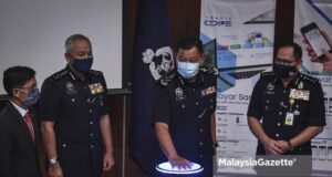 Inspector-General of Police (IGP) Tan Sri Abdul Hamid Bador and his Deputy, Datuk Sri Acryl Sani Abdullah Sani (second left) doing the launch gimmick for the MyBayar Saman Portal and Mobile Application at the Bukit Aman Police Headquarters, Kuala Lumpur. PIX: HAZROL ZAINAL / MalaysiaGazette / 25 MARCH 2021