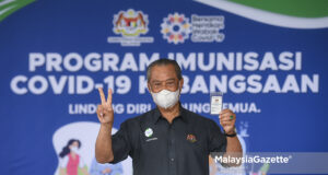 fully vaccinated Prime Minister, Tan Sri Muhyiddin Yassin showing his Covid-19 vaccination card after he received his second dose of Pfizer-BioNTech Covid-19 vaccine injection during the National Covid-19 Immunisation Programme at the Precinct 18 Putrajaya Health Clinic. PIX: SYAFIQ AMBAK / MalaysiaGazette / 17 MARCH 2021. interstate travel abroad overseas