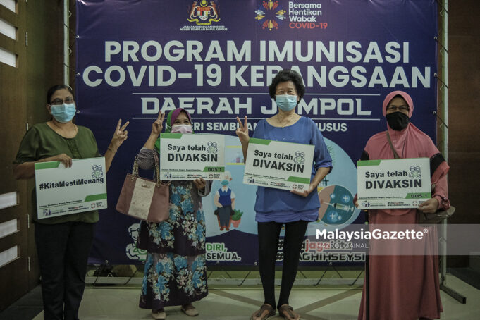 walk-in Recipients of Covid-19 vaccine from the senior citizens group holding placards after receiving their Pfizer-BioNTech injection during the Second Phase of National Covid-19 Immunisation Programme at the Vaccination Centre in the Jempol District and Land Office, Negeri Sembilan. PIX: HAZROL ZAINAL / MalaysiaGazette / 21 APRIL 2021.
