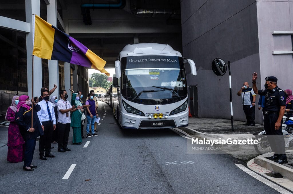 Deputy Vice-Chancellor (Academics and International), Prof. Dr Roziah Janor (left) of UiTM doing the flag off gimmick for Ops Pulang Aidilfitri to send students back to their hometown for the Aidilfitri holidays outside the Dewan Agong Tuanku Canselor (DATC), UiTM Shah Alam.     PIX: MOHD ADZLAN / MalaysiaGazette / 07 MAY 2021.
