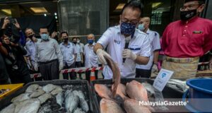 Minister of Domestic Trade and Consumer Affairs Datuk Seri Alexander Nanta Linggi examining the fresh fish during a visit to the Prihatin Raya Sales Programme booth at KPDNHEP, Putrajaya. PIX: AFFAN FAUZI / MalaysiaGazette / 07 MAY 2021.